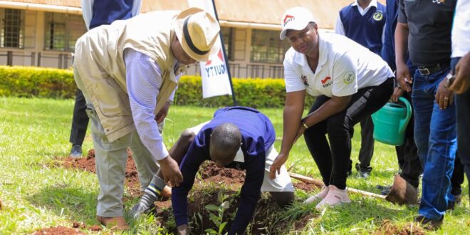 Tree planting at Busoga College Mwiri. To the left is Kenya High Commissioner to Uganda Joash Maangi, at centre is a student of the college and right is Elizabeth Wahito, Project Manager, Equity Bank.