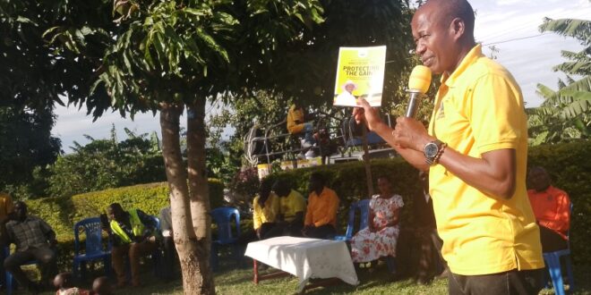 Bamuturaki showing his supporters the manifesto book which was given by the NRM party chairman c