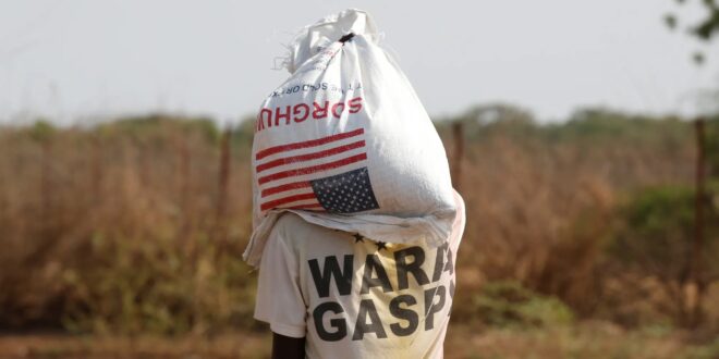 REFUGEE cadrrying food -kakuma Baz Ratner Reuters
