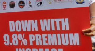 A Cosatu affiliated member holds up a placard in protest against GEMS' 9.8% premium hike during a National Day of Action in Pretoria on 26 February 2026.