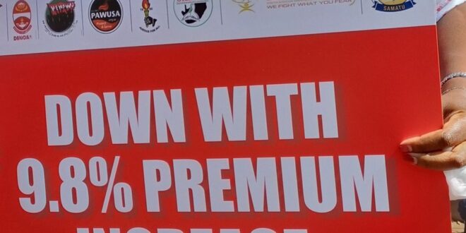 A Cosatu affiliated member holds up a placard in protest against GEMS' 9.8% premium hike during a National Day of Action in Pretoria on 26 February 2026.