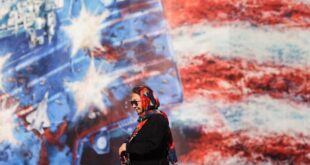 An Iranian woman walks past an anti-US billboard in Tehran, Iran on February 26, 2026. M