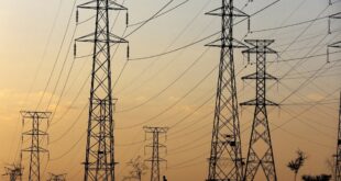 FILE: A man walks beneath electricity pylons.
