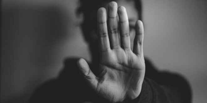 A woman raises her hand, calling for an end to GBV.
