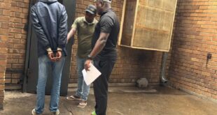 A suspect seen handcuffed after handing himself over to the police.