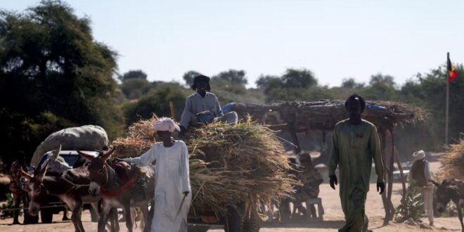 People travel between Chad and Sudan, amid the ongoing conflict between the paramilitary Rapid Support Forces (RSF) and the Sudanese Army, at the Tine border post in eastern Chad on November 22, 2025.