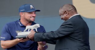LIV Golf SA title winner Bryson DeChambeau holds the trophy together with President Cyril Ramaphosa.