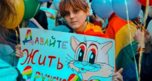Young participant at Coming Out's rally for LGBT* rights holds a sign that states "Let's Live in Peace." (Photo courtesy of Coming Out)