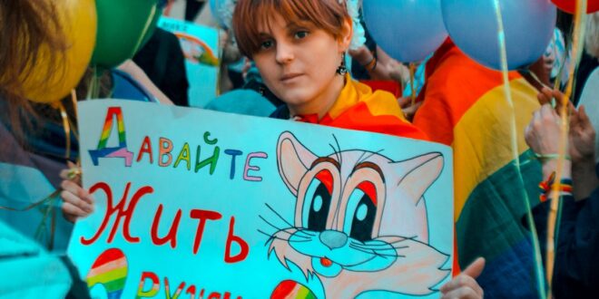 Young participant at Coming Out's rally for LGBT* rights holds a sign that states "Let's Live in Peace." (Photo courtesy of Coming Out)
