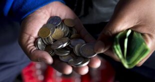 A street trader counts out change for a customer in Durban.