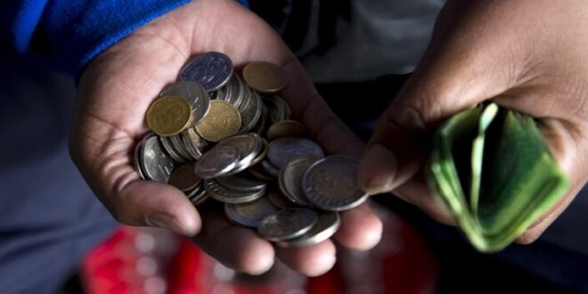 A street trader counts out change for a customer in Durban.