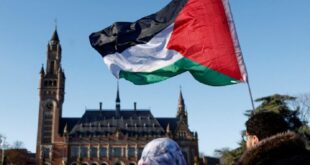 Protesters hold a Palestinian flag as they gather outside the International Court of Justice (ICJ) as judges rule on emergency measures against Israel following accusations by South Africa that the Israeli military operation in Gaza is a state-led genocide, in The Hague, Netherlands, January 26, 2024.